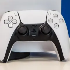 Biały kontroler DualSense od PS5 na jasnym tle.