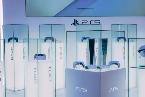 Konsola PlayStation 5 i kontrolery DualSense w witrynach sklepowych.