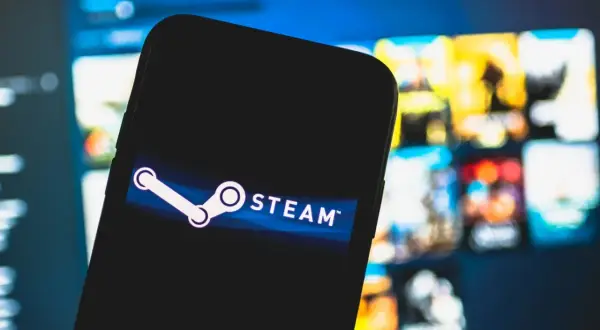 Smartfon z logo Steam na tle ekranu z grami.