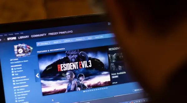 Ekran laptopa z interfejsem sklepu Steam, widoczna okładka gry Resident Evil 3.